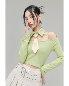 Woman in a green off-shoulder top and pleated skirt with a mini tie