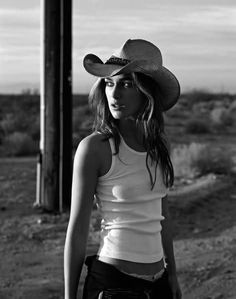 Woman in a cowboy hat and tank top in a desert setting