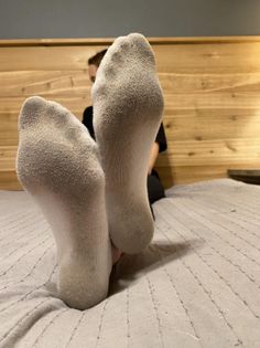 Close up of feet in dirty white socks on a bed
