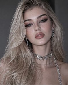 Woman with blonde hair and freckles wearing a sparkling choker and earrings