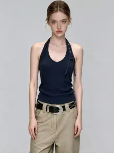 Woman in a dark blue halter top and khaki pants with a black belt