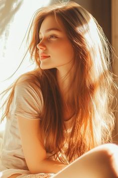 Young woman with long red hair in soft golden hour lighting