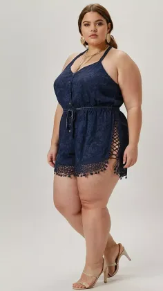 Woman in a dark blue romper with lace-up sides and high heels posing in a studio