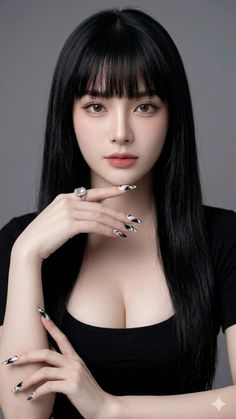 Woman with long black hair and bangs wearing a black top and jewelry