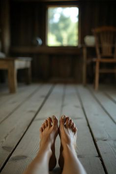 Bare feet on a wooden floor with a window in the background