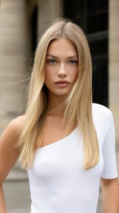 Blonde woman in a white top with long hair blowing in the wind