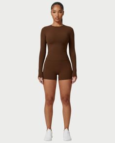 Woman in brown long-sleeve top and shorts with white sneakers