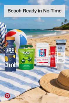 Beach essentials on a striped towel with the ocean in the background