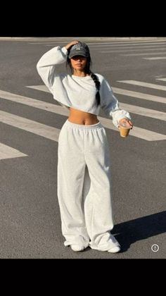 Woman in a cropped sweatshirt and wide leg pants on a street