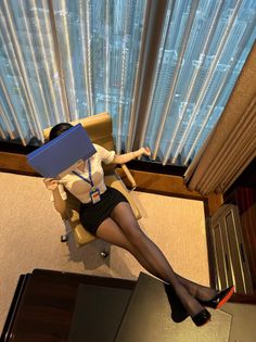 Woman in office attire and pantyhose posing in an office with a cityscape view