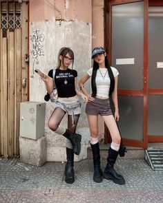 Two women in streetwear outfits posing on a city street