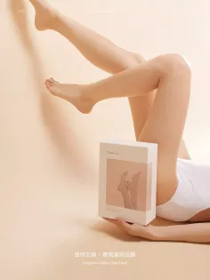 Person in a white bodysuit holding a product box with legs raised