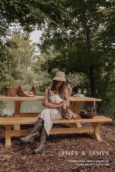 Woman with two dogs sitting on a picnic bench in a forest setting