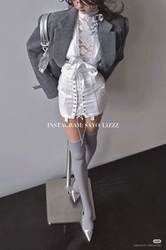 Woman in a corduroy jacket, lace top, corset skirt, and thigh-high socks