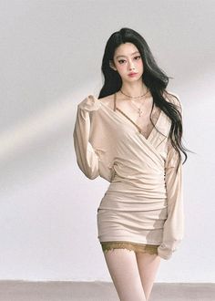 Woman with long black hair in a beige dress with lace trim and exposed shoulder