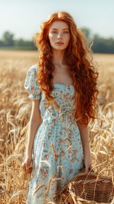 Woman with long red hair in a floral dress standing in a wheat field