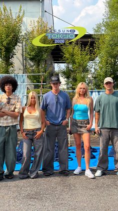 Five young adults posing outdoors in casual clothing