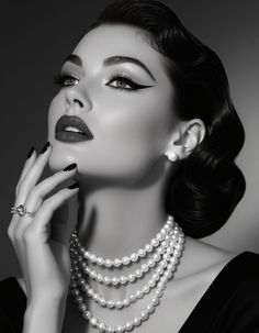 Woman in vintage style with pearl necklace and dramatic makeup