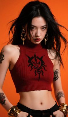 Woman with long dark hair, tattoos, and a red crop top against an orange background