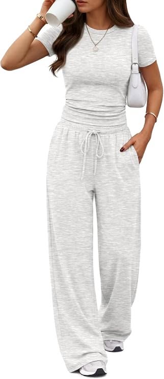 Woman in a gray t-shirt and wide leg pants holding a coffee cup