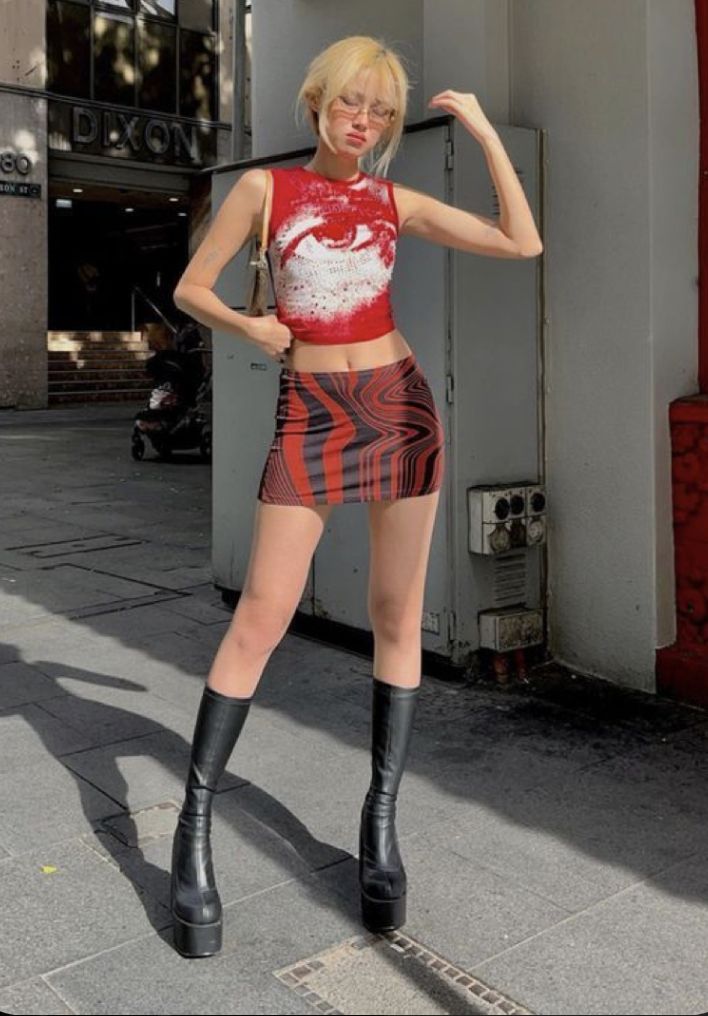 Woman with blonde hair in a crop top and mini skirt on a sunny street