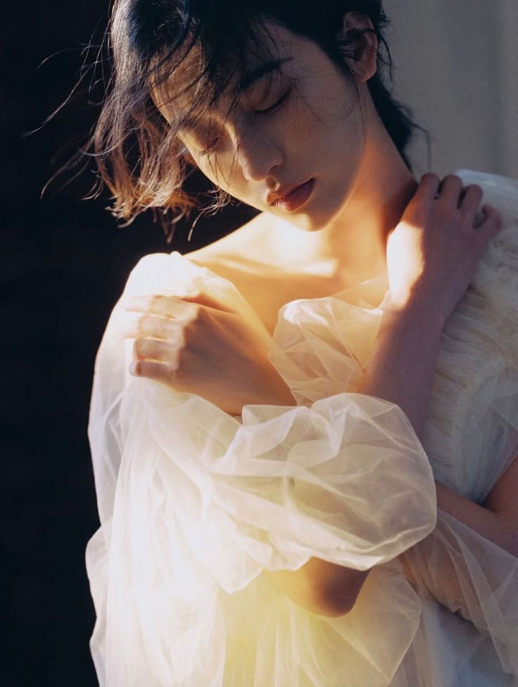 Woman in a white dress with closed eyes and soft backlight