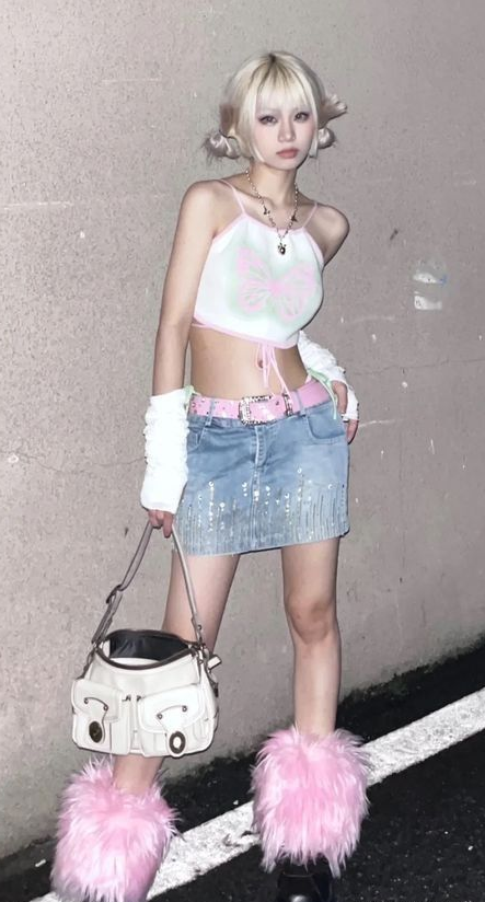 Woman with blonde pigtails wearing a crop top and denim skirt with furry boots