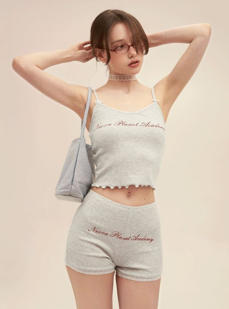 Woman in a gray ribbed tank top and shorts with a choker and glasses