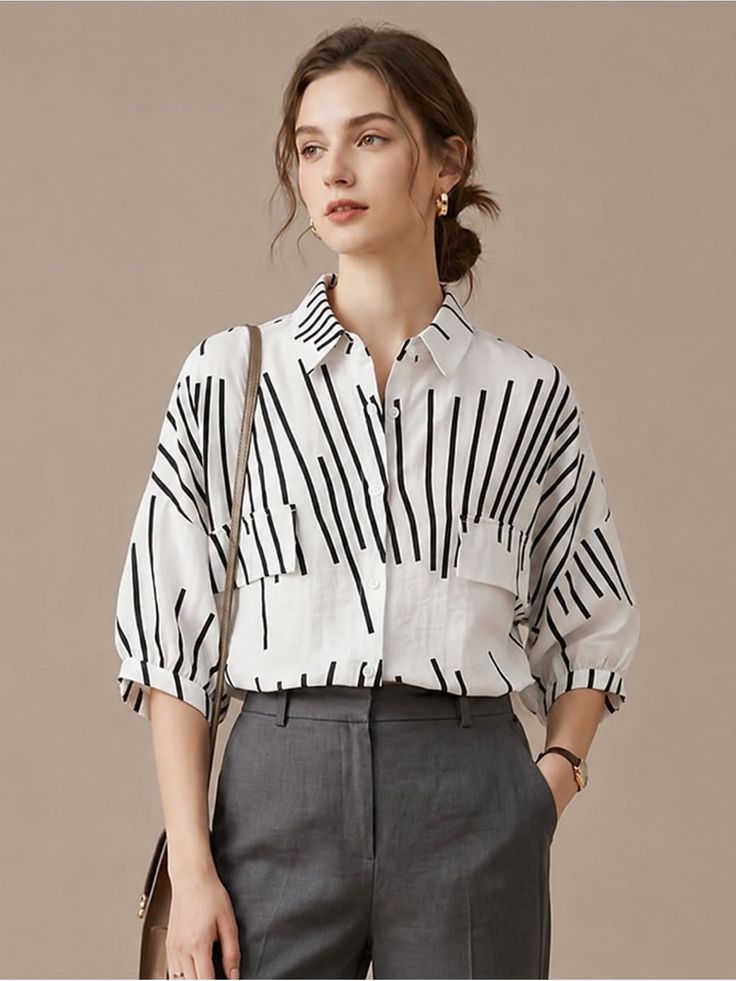 Woman in a white striped shirt and grey pants with a bun hairstyle