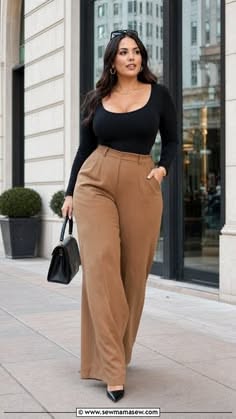 Woman in a black top and wide leg pants walking on a city street