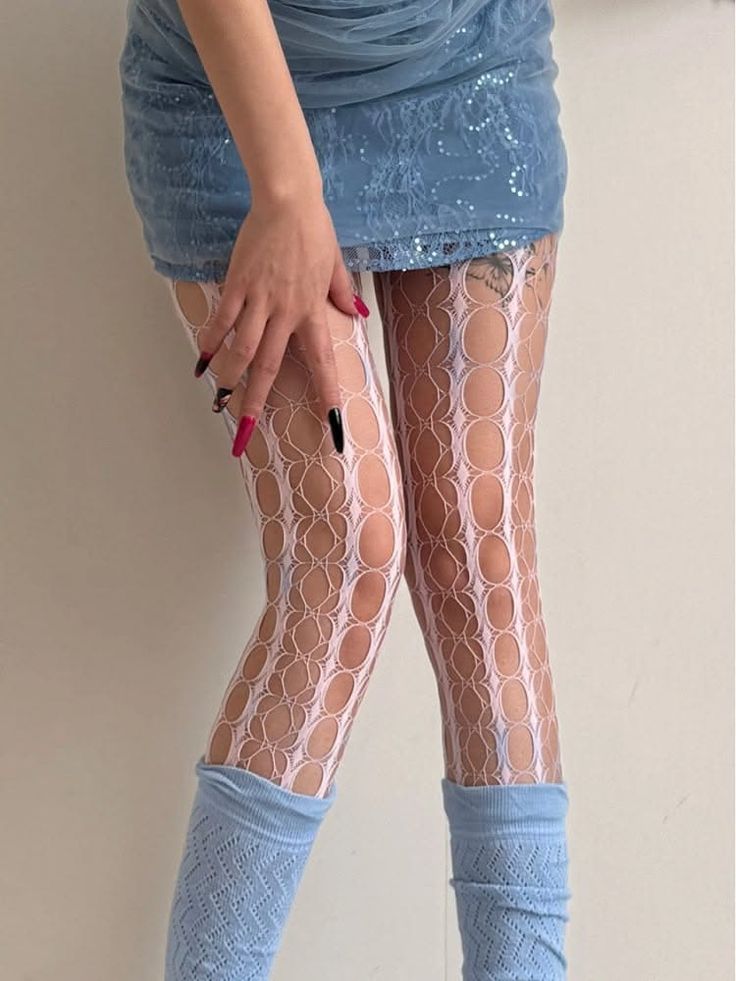 Person wearing a blue mini skirt, fishnet stockings, and leg warmers