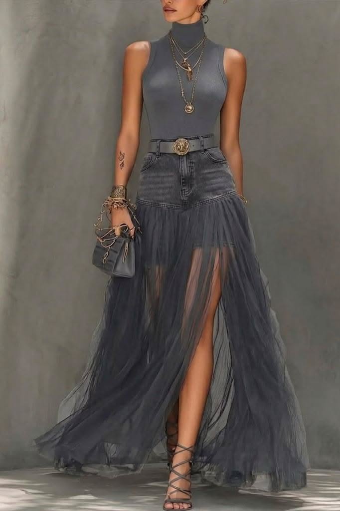 Woman in a gray turtleneck top and a denim and tulle skirt with a high slit