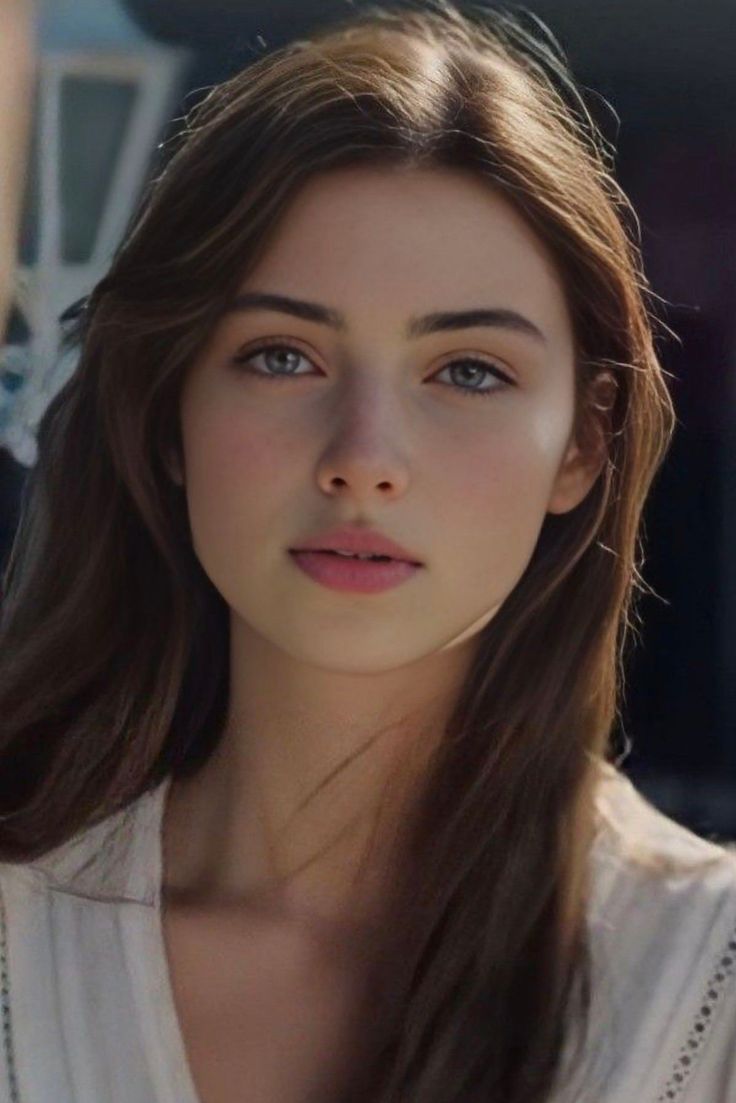 Young woman with long brown hair and blue eyes in soft lighting