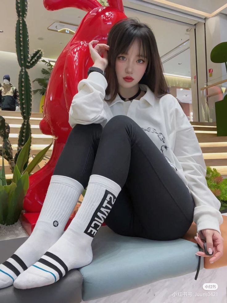 Woman with long hair and red lips sitting indoors