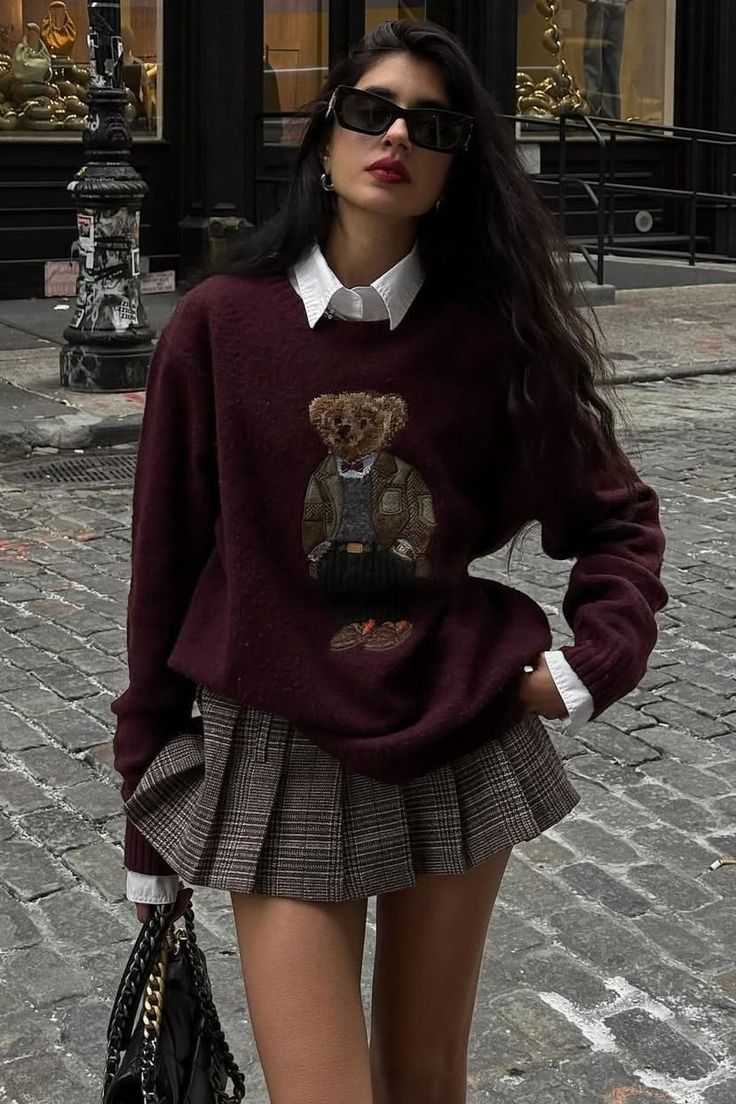 Woman in a teddy bear sweater and plaid skirt on a cobblestone street