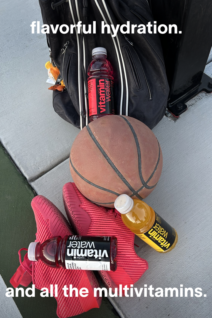 Basketball, red sneakers, and vitamin water bottles on concrete ground