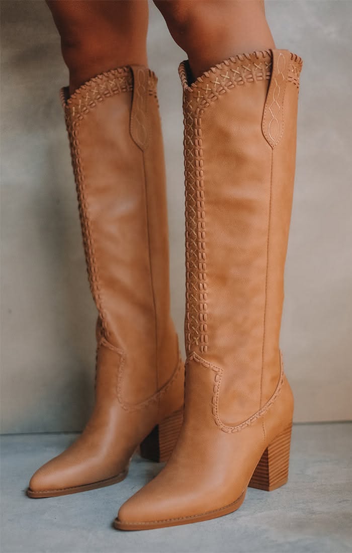 Pair of tan leather knee-high boots with decorative stitching and block heels