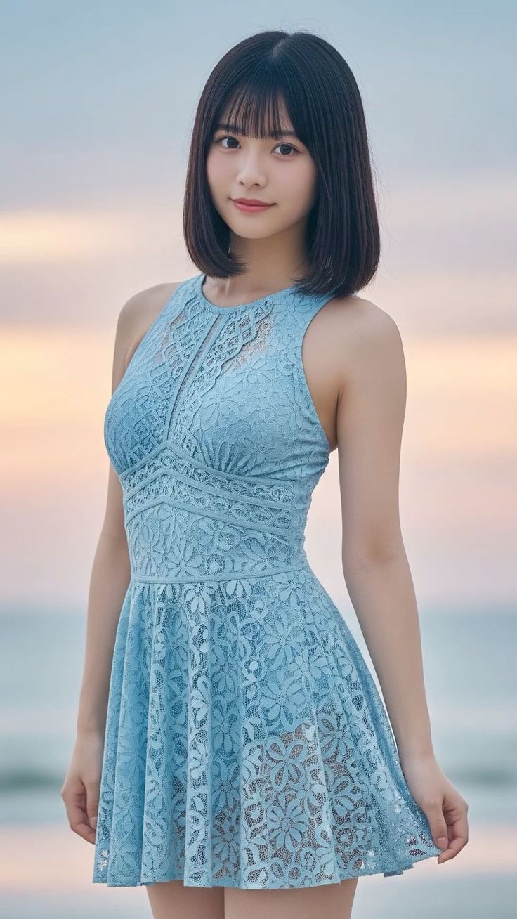 Woman in a blue lace dress with short hair outdoors at sunset