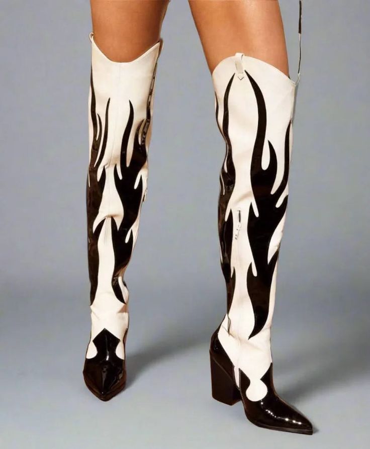 Person wearing thigh-high boots with a black and white flame pattern