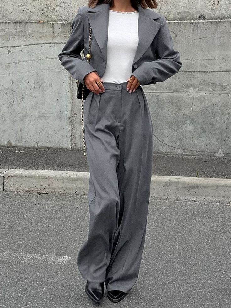 Woman in a gray suit with wide leg pants and a cropped blazer outdoors