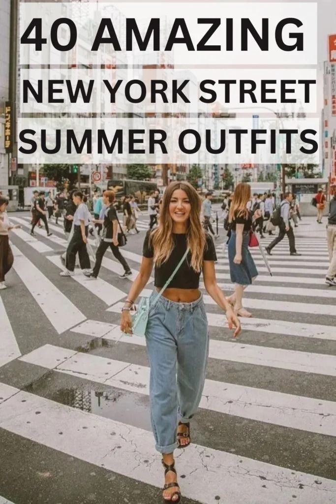 Woman in a black crop top and jeans walking on a city street crosswalk