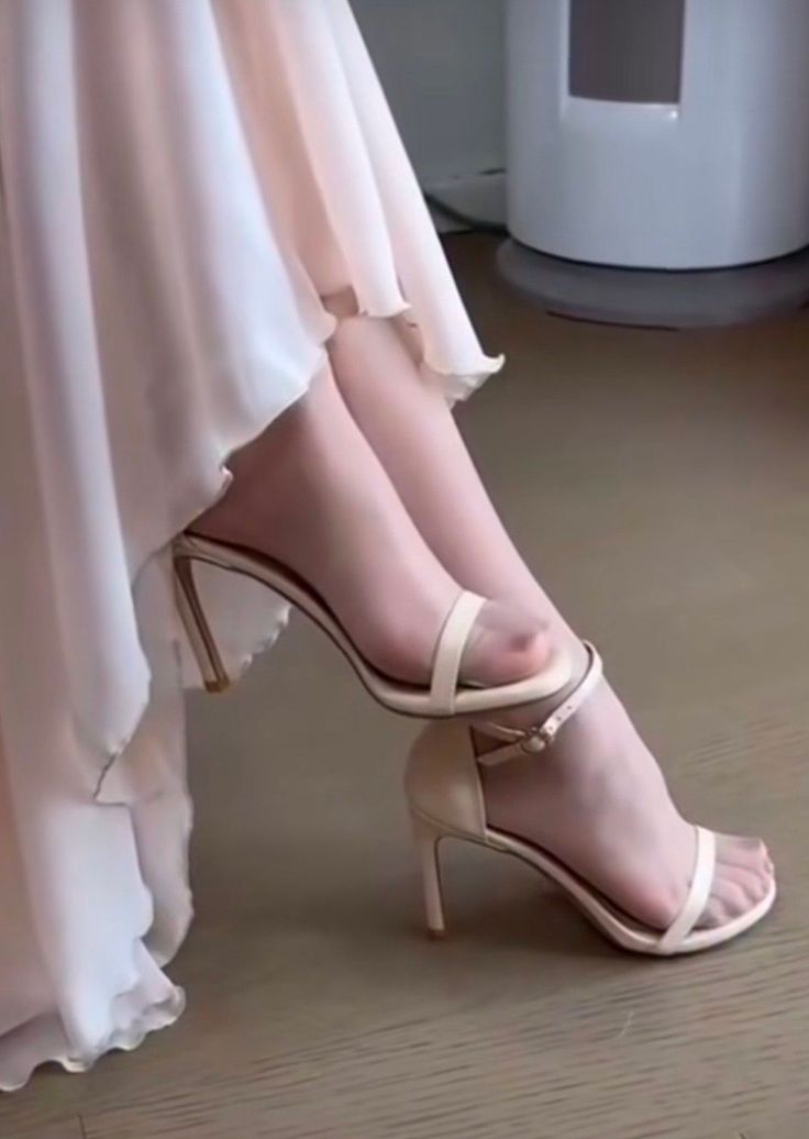 Woman's legs in sheer stockings and high heels with a light dress