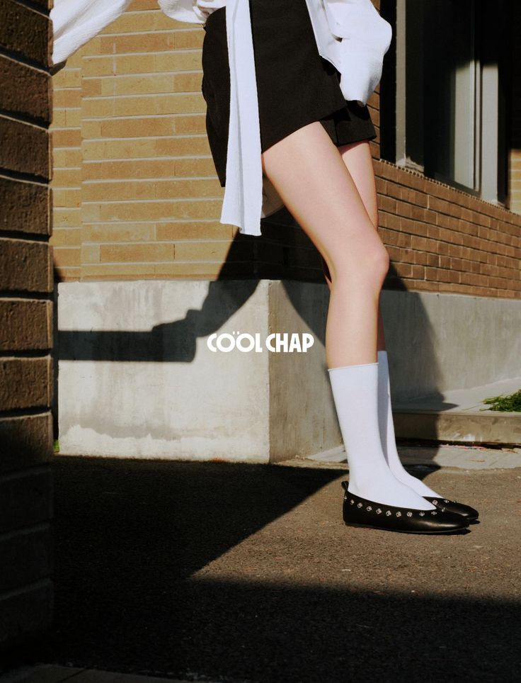 Person in black shorts and white shirt with exposed legs and white socks