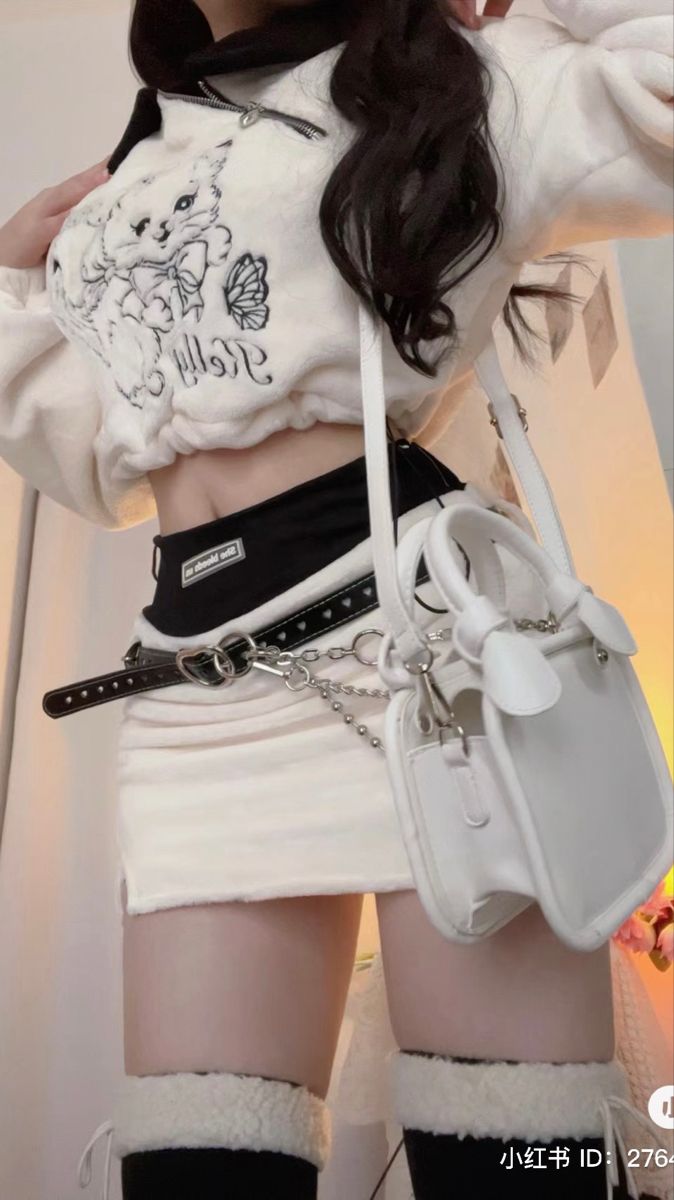 Person in a white cropped top and mini skirt with a heart belt