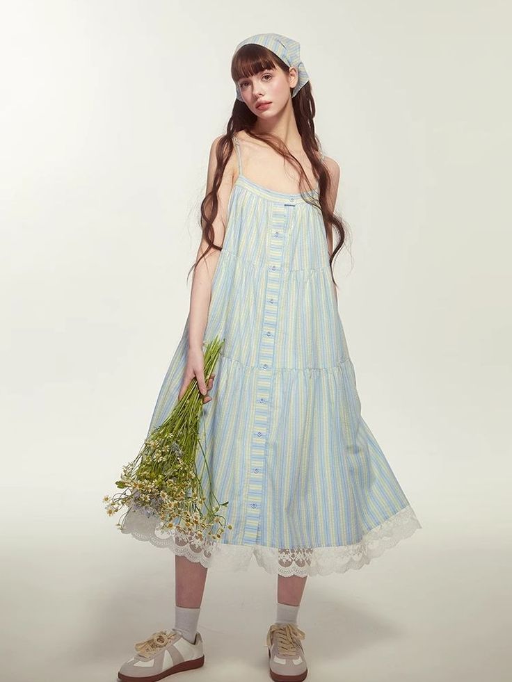 Woman in a striped dress and head scarf holding a bouquet of flowers