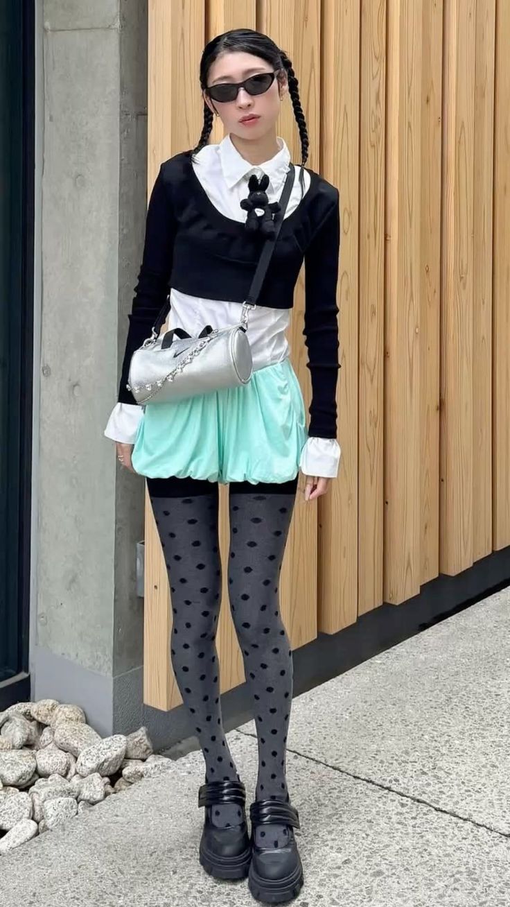 Woman with braided hair and sunglasses wearing a mint green skirt and polka dot tights