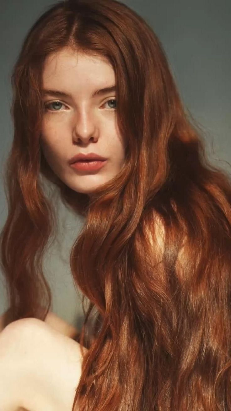 Woman with long red hair and blue eyes in a soft lighting portrait
