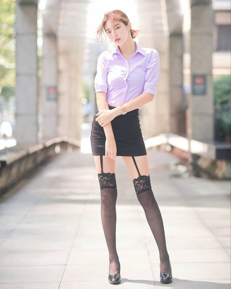Woman in a mini skirt and garter stockings posing outdoors