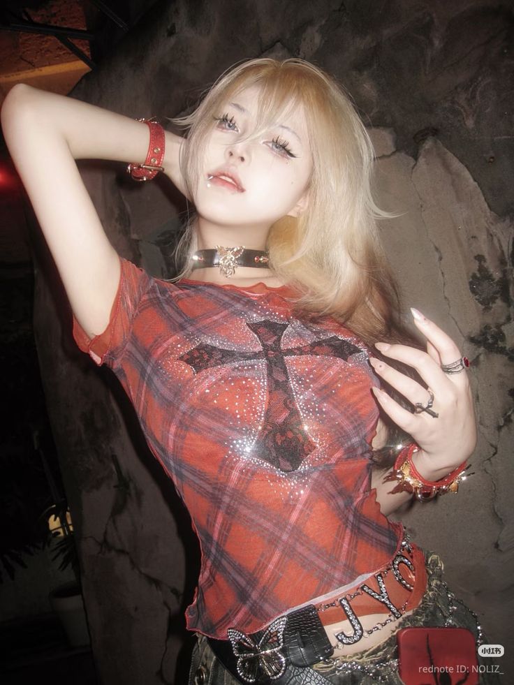 Blonde woman in a plaid shirt with a cross design and gothic accessories