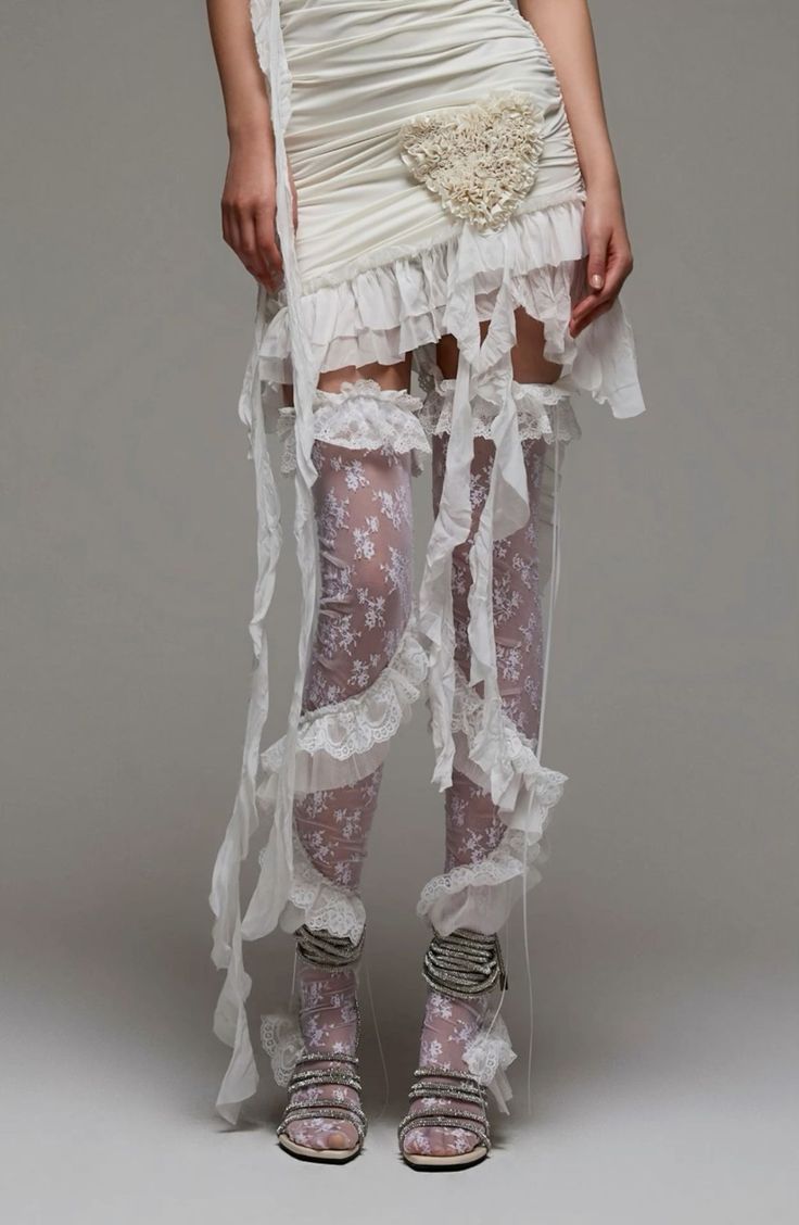 Person in a white ruffled dress and lace stockings with exposed skin